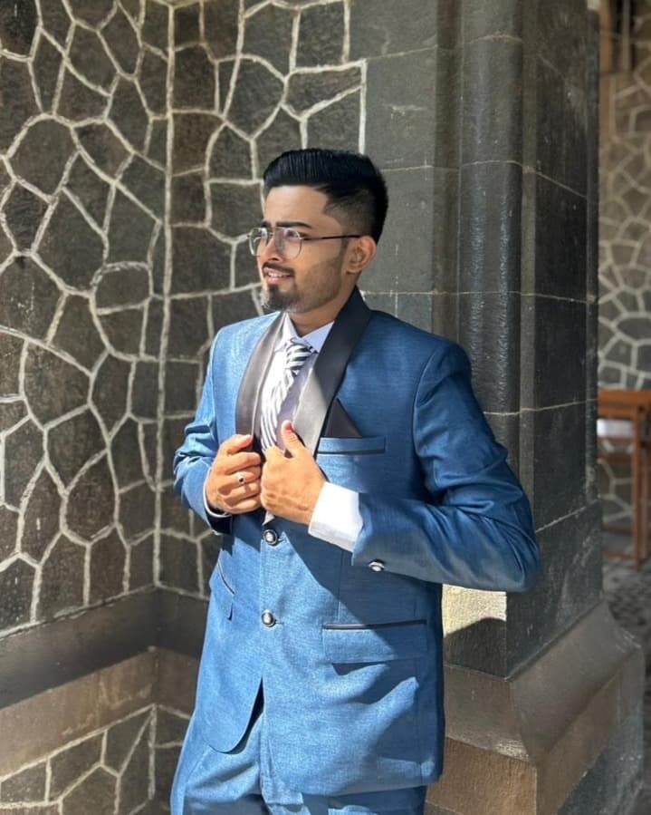 Ankit Vala, founder, chief executive officer and director of Stucare Innovation and Creation Private Limited, standing in a blue three-piece suit beside a stone building