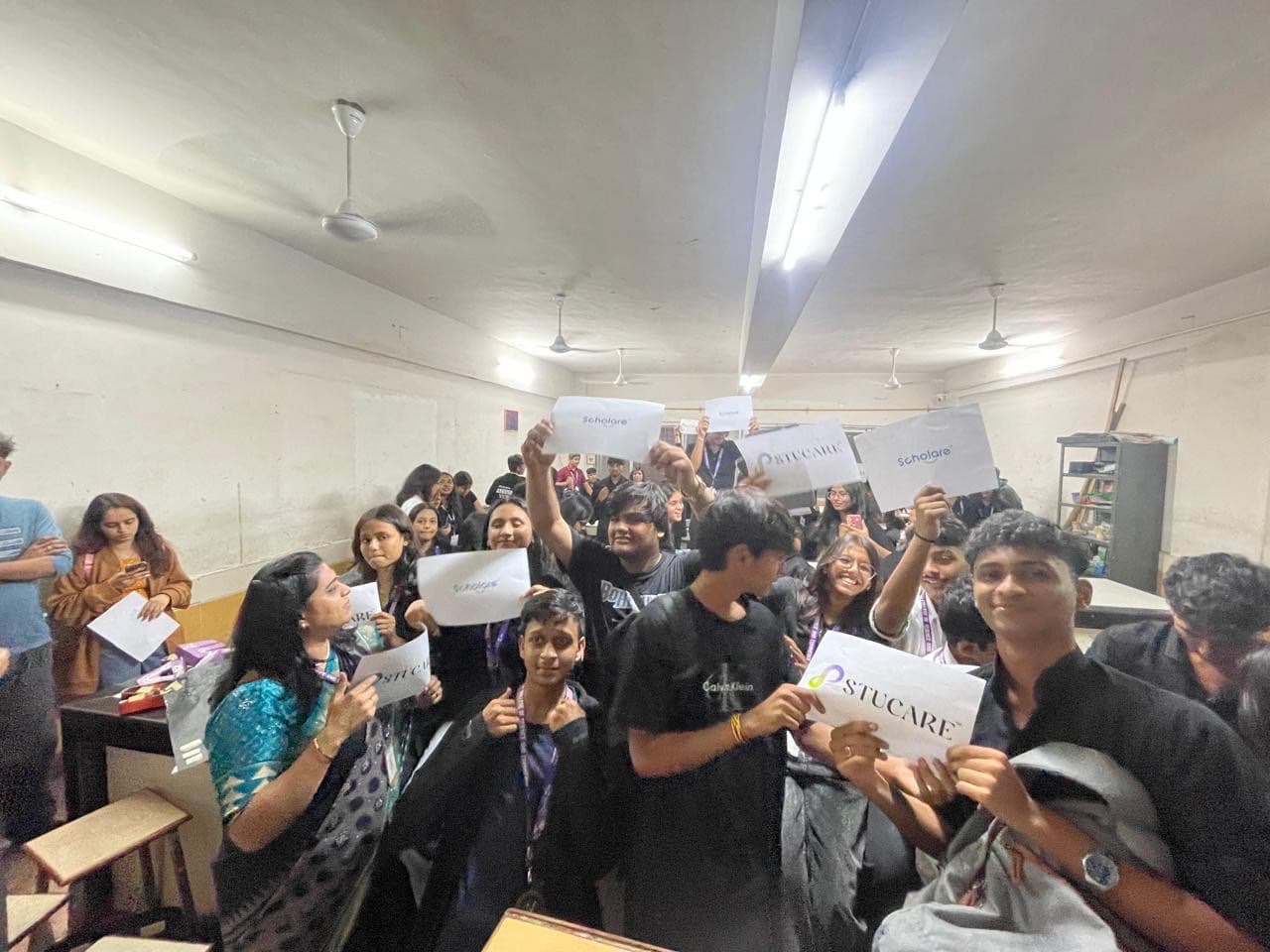 Students holding Scholare and Stucare cards in a classroom during JTGYA 2K25